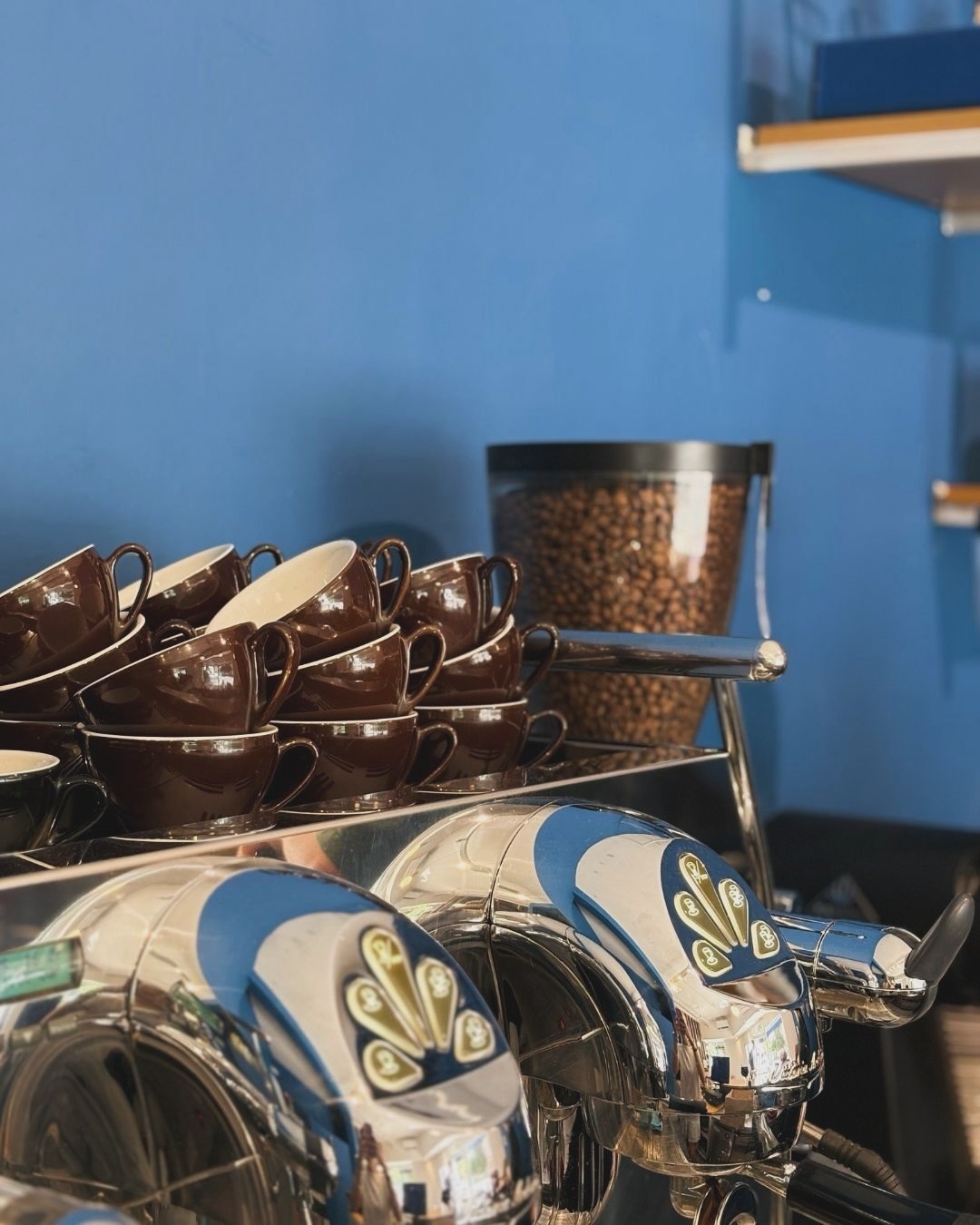 Tazas, granos y máquina espresso en Café Chico